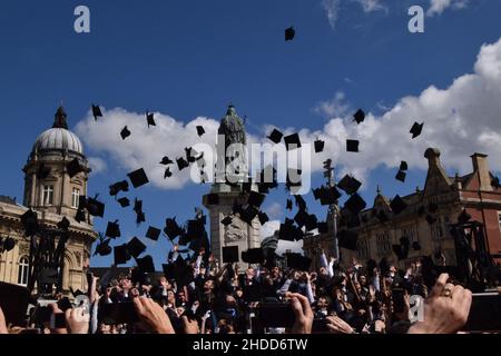 Les diplômés de l'université britannique lancent leurs mortaboards dans les airs Banque D'Images
