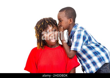 un petit garçon mignon racontant un secret de famille à l'intérieur de l'oreille de sa mère. Banque D'Images