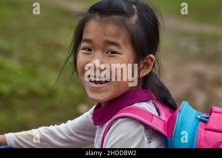 Une jeune fille vietnamienne avec un sourire éclatant regarde l'appareil photo Banque D'Images