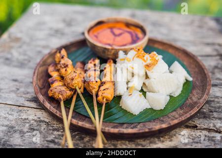 Satay de poulet indonésien ou sate Ayam servi avec du lontong, de la sauce soja et de la sauce aux arachides Banque D'Images