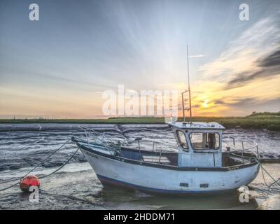 Coucher de soleil sur de petits bateaux de pêche amarrés Banque D'Images