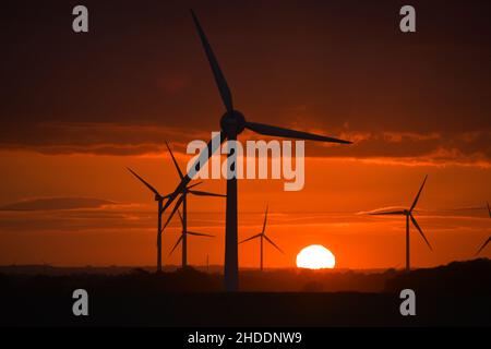 Coucher de soleil spectaculaire derrière des éoliennes géantes Banque D'Images