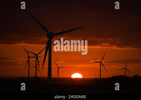 Coucher de soleil spectaculaire derrière des éoliennes géantes Banque D'Images