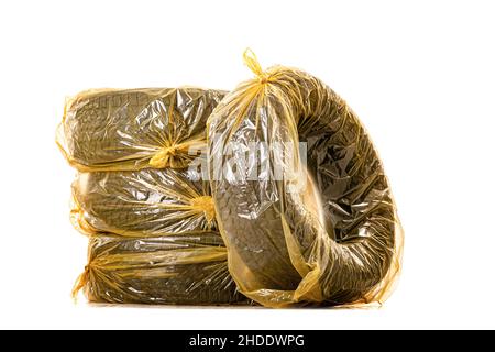 Pneus de voiture dans des sacs jaunes pour le stockage.Jeu de quatre pneus d'hiver isolés sur fond blanc. Banque D'Images