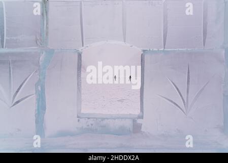 Lake Louise, Canada - 22 2021 décembre : les gens du tourisme sur le lac Louise gelé ont tiré à travers un mur de briques de glace Banque D'Images