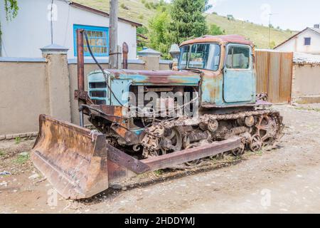 Ancien bulldozer rouillé dans le village d'Ak Suu près de Karakol au Kirghizistan Banque D'Images