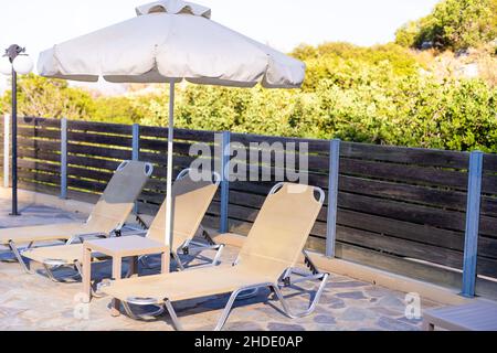 Deux chaises longues à côté d'une piscine. Banque D'Images