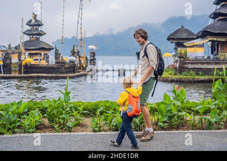 Père et fils dans l'arrière-plan de Pura Ulun Danu Bratan, Bali. Hindu Temple entouré de fleurs sur le lac Bratan, Bali. Temple de l'eau dans les grands Shivaite Banque D'Images