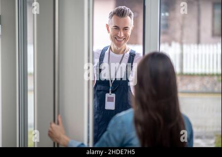 Femme avec dos à la caméra ouvrant la porte à l'homme Banque D'Images