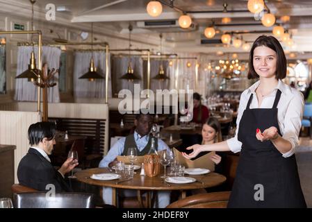 Une serveuse rencontre les clients au restaurant Banque D'Images