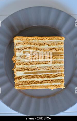 Morceau de gâteau au miel avec deux couches de marmelade de poire sur l'assiette grise Banque D'Images