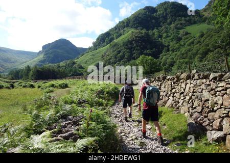 Deux hommes marchant jusqu'au Wainwright 'Eagle Crag' sur le sentier d'un océan à l'autre (C2C) près de Stonethwaite à Borrowdale, Lake District National Park, Royaume-Uni, Banque D'Images