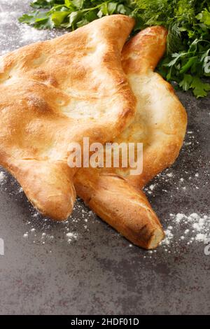 Shotis puri ou shoti est un pain géorgien fait avec de la farine de blé entier, du sel, de l'eau, et de la levure gros plan sur la table.Verticale Banque D'Images