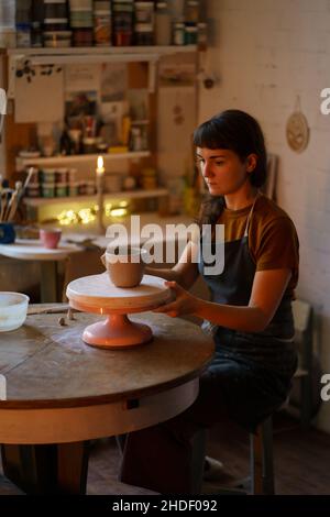 Femme détendue passez la soirée dans un studio de poterie occupé avec des travaux manuels après le stress au travail.Art thérapie Banque D'Images