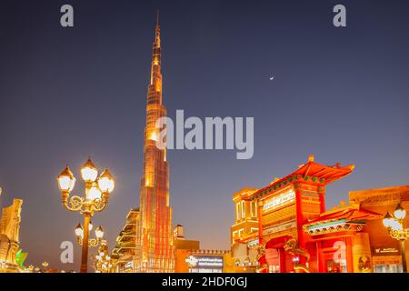 Dubaï, Émirats arabes Unis, 10.01.21.Parc d'attractions Global Village la nuit avec Burj Khalifa miniature et pagodes illuminés, croissant de lune dans le ciel, espace de copie Banque D'Images