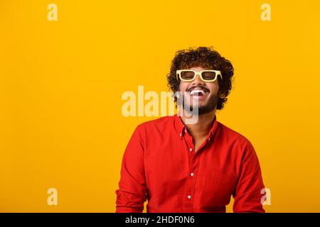 Positif barbu homme riant dehors fort, chatouillement et hystériquement riant avec l'anecdote, s'amuser.Studio d'intérieur isolé sur fond orange Banque D'Images