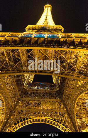 Vue nocturne verticale à angle bas de la Tour Eiffel illuminée de Paris, France Banque D'Images