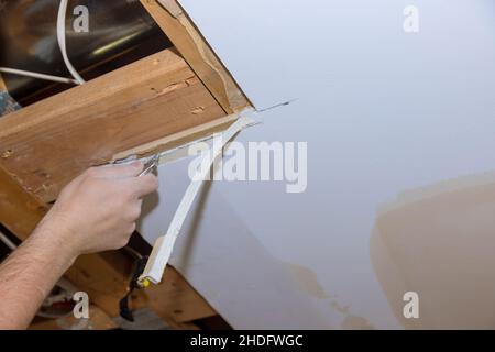 Maison dommages intérieurs pour panneau de cloison sèche avec réparation maison de l'homme coupant le placoplâtre Banque D'Images