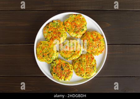 Côtelettes de légumes de courgettes, carottes, herbes en plaque blanche. Vue sur le dessus, plat Banque D'Images