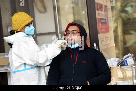 (220106) -- PATNA, le 6 janvier 2022 (Xinhua) -- Un agent de santé recueille un échantillon d'écouvillon pour les tests COVID-19 auprès d'un homme dans un hôpital de Patna, en Inde, le 6 janvier 2022.(STR/Xinhua) Banque D'Images