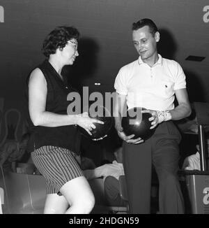 1960, histoire, des papillons à dix épingles, homme et femme tenant leurs balles, avec la femme utilisant deux doigts et son pouce dans les trois trous, Columbus, Ohio, Etats-Unis.En 1950s et 60s, un passe-temps populaire de lléiure aux États-Unis, dix-pin était également un sport amateur compétitif, avec une structure de ligue organisée et compétitive, avec des équipes hommes et femmes.En 1958, la Professional Bowlers Association (PBA) a été créée. Banque D'Images