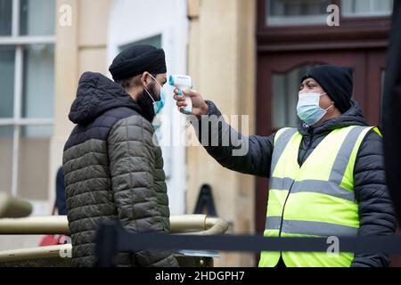 Les membres du personnel vérifient que des gens font la queue devant un centre de vaccination le jour de Noël à Londres alors que la variante d'Omicron se propagera. Banque D'Images