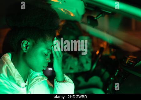 Triste couple africain en querelle assis en voiture la nuit, déprimé homme africain et femme en auto Banque D'Images