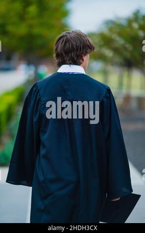 Mise au point sélective d'un homme de derrière portant une robe de graduation Banque D'Images