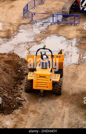 Travailleur sur le chantier et véhicule en pause travail (pieds en haut sur le saut, se reposer dans un camion-benne jaune) - centre-ville de York, North Yorkshire, Angleterre Royaume-Uni Banque D'Images