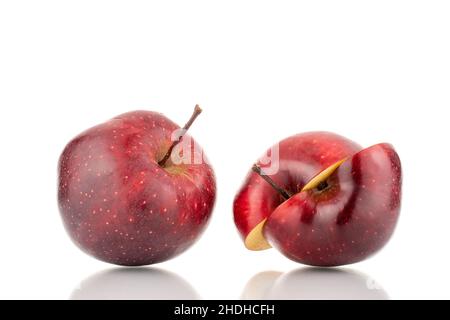 Une pomme rouge mûre entière et deux moitiés, en gros plan, isolées sur du blanc. Banque D'Images