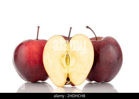 Deux pommes rouges entières et une moitié d'une pomme rouge mûre, en gros plan, isolées sur du blanc. Banque D'Images