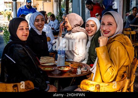 Un groupe de jeunes femmes jordaniennes dégusteront un petit-déjeuner devant Un café à Aqaba, dans le gouvernorat d'Aqaba, en Jordanie. Banque D'Images