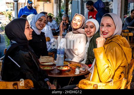 Un groupe de jeunes femmes jordaniennes dégusteront un petit-déjeuner devant Un café à Aqaba, dans le gouvernorat d'Aqaba, en Jordanie. Banque D'Images