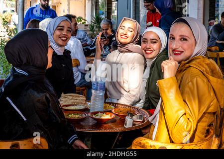 Un groupe de jeunes femmes jordaniennes dégusteront un petit-déjeuner devant Un café à Aqaba, dans le gouvernorat d'Aqaba, en Jordanie. Banque D'Images