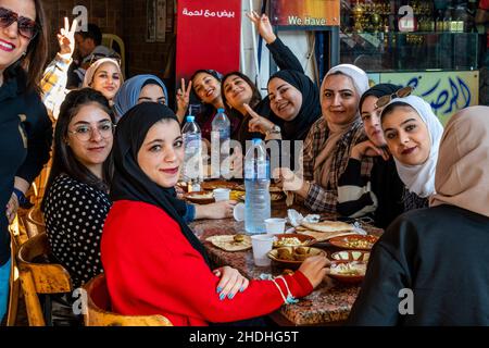 Un groupe de jeunes femmes jordaniennes dégusteront un petit-déjeuner devant Un café à Aqaba, dans le gouvernorat d'Aqaba, en Jordanie. Banque D'Images