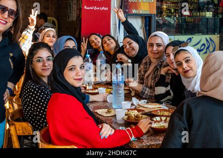 Un groupe de jeunes femmes jordaniennes dégusteront un petit-déjeuner devant Un café à Aqaba, dans le gouvernorat d'Aqaba, en Jordanie. Banque D'Images