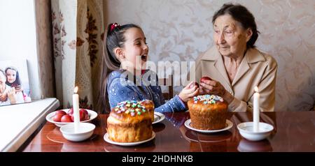 Concept de Pâques. La grand-mère avec sa petite-fille tient des œufs de Pâques à la maison Banque D'Images