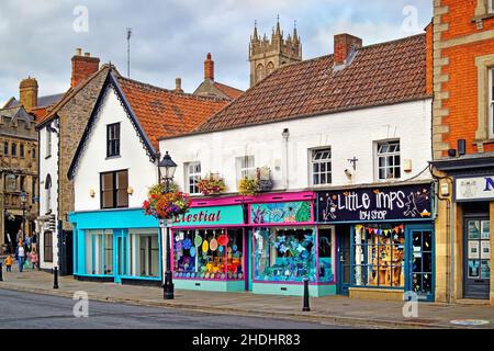 Royaume-Uni, Somerset, Glastonbury, Magdalene Street Shops et l'église Saint-Jean-Baptiste Banque D'Images