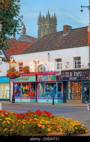 Royaume-Uni, Somerset, Glastonbury, Magdalene Street Shops et l'église Saint-Jean-Baptiste à Dusk. Banque D'Images