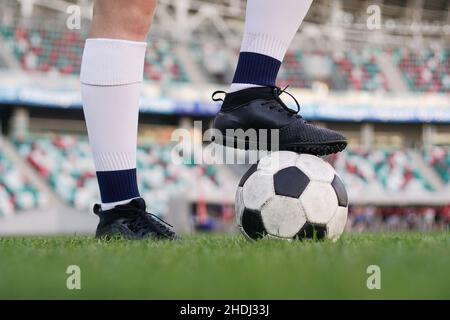 Jambes d'une joueuse de football sur le ballon de football au stade, gros plan Banque D'Images