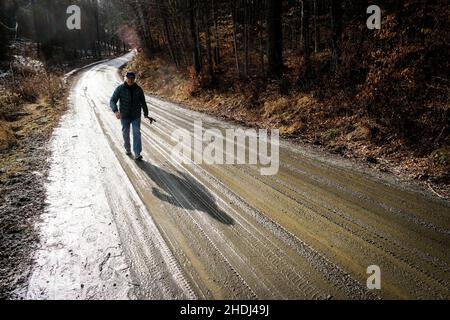 Un vieux solitaire marche le long d'une route de terre rurale dans l'est de Montpelier, VT, Nouvelle-Angleterre, Etats-Unis. Banque D'Images