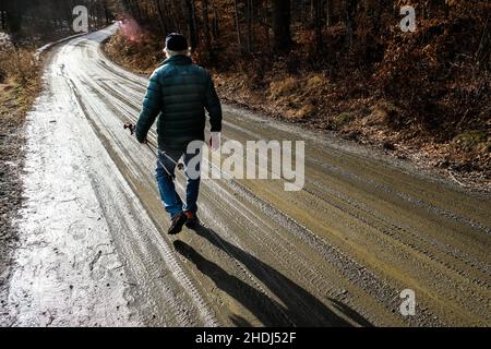 Un vieux solitaire marche le long d'une route de terre rurale dans l'est de Montpelier, VT, Nouvelle-Angleterre, Etats-Unis. Banque D'Images