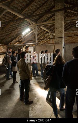 AUSCHWITZ, POLOGNE - Mars 30 2012 les visiteurs dans une caserne de concentration écoutent un guide Banque D'Images