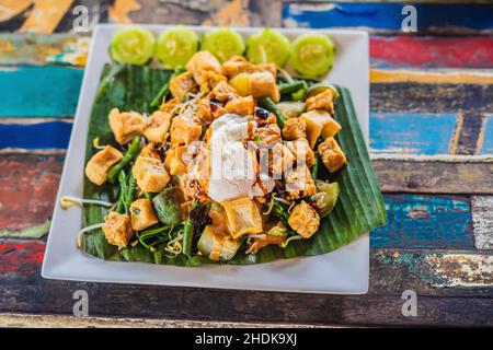 Gado-gado salade indonésienne servi avec sauce aux arachides. Ingrédients : tofu, épinards, haricots, soja, germes de pommes de terre, concombres et œufs durs Banque D'Images