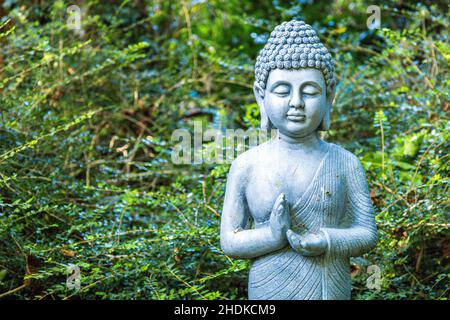 Une magnifique statue de Bouddha debout au milieu d'un jardin de style Zen japonais pour tous à voir et à être inspiré par. Banque D'Images