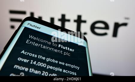 Smartphone avec le site Web de la société irlandaise de bookmaking Flutter Entertainment plc à l'écran devant le logo.Faites la mise au point dans le coin supérieur gauche de l'écran du téléphone. Banque D'Images