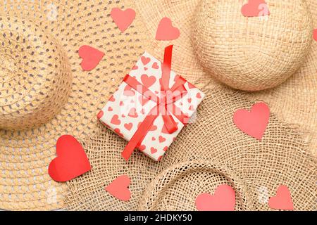 Boîte cadeau avec coeurs en papier sur chapeaux en paille.Célébration de la Saint-Valentin Banque D'Images