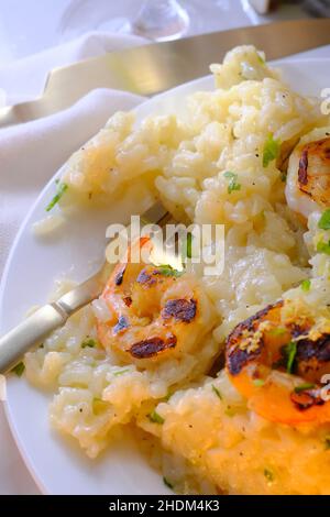 Dîner de risotto aux crevettes italiennes raffiné servi avec un verre de grigio de pinot Banque D'Images