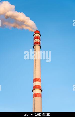 Cheminée industrielle fumant le jour d'hiver ensoleillé Banque D'Images