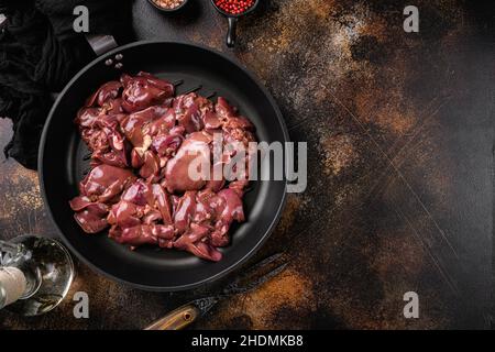 Foie de poulet cru, sur un fond de table rustique foncé ancien, plan de dessus, avec espace de copie pour le texte Banque D'Images